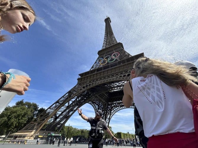 A man is seen climbing the Eiffel Tower, prompting an evacuation hours before closing ceremony