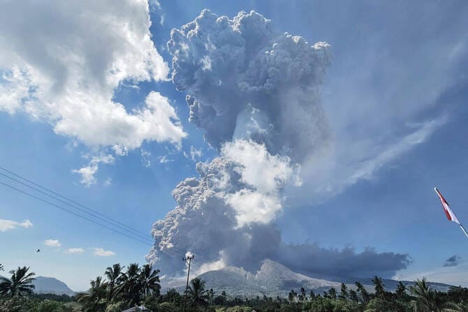 Residents wear masks as volcanic ash blankets villages near erupting Indonesian volcano
